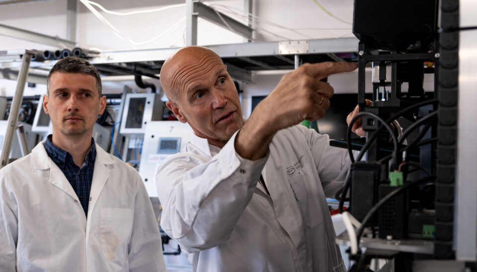 Jon-Terje Lepsøy (t.h.) og Mihai Dan viser frem OceanWall-systemet, der hvert enkelt dyr overvåkes og fôres av en robot.